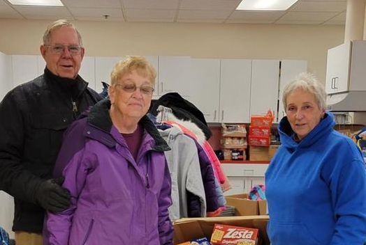 members  of the old town rotary in front of boxes of food